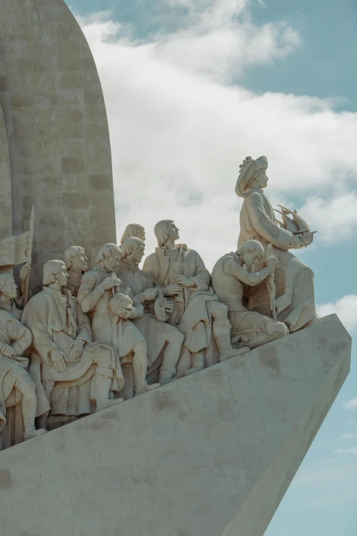 the statue has many statues on it and a sky background