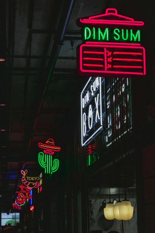 neon signs lit up the night sky in a shopping area