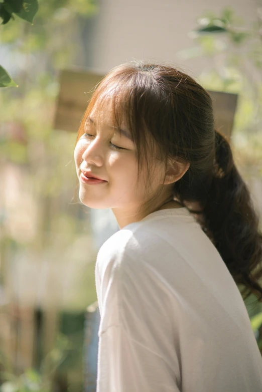 an asian woman wearing a white shirt looking at the sky