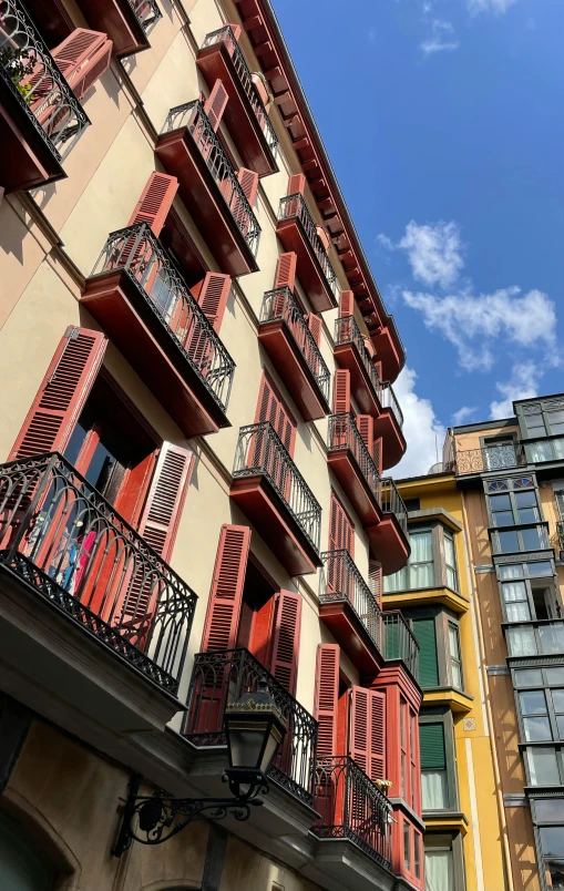 red and yellow balconies are hanging from the side of the building