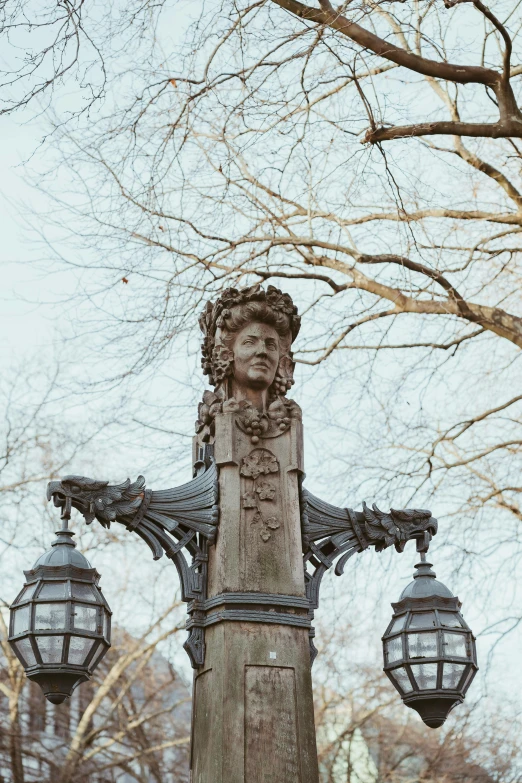 this statue has a crown on his head and two street lamps