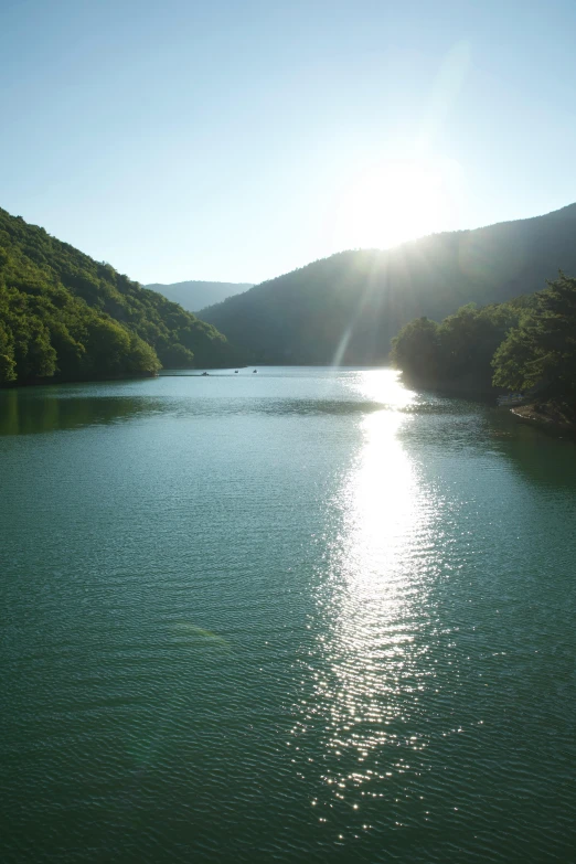 the sun is rising over the mountains above the lake