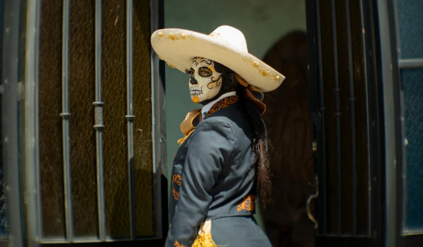 woman in a skeleton costume on the street wearing a large sombrero