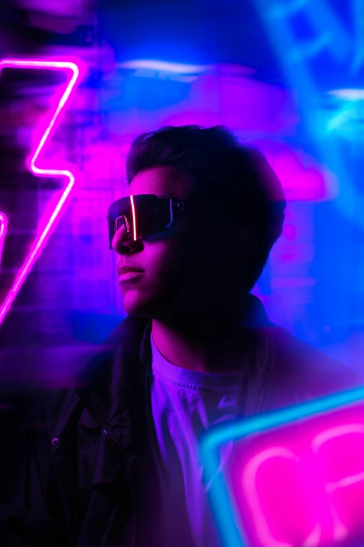 a person wearing sunglasses in the middle of a neon lit area