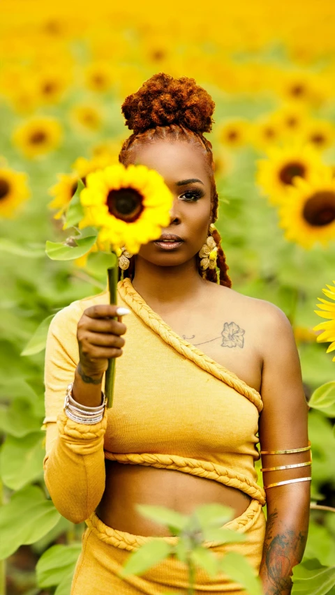 a woman holds a flower on the sunflower field