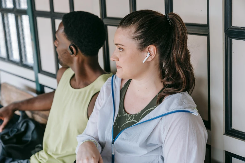 a woman listening to headphones sitting next to a man