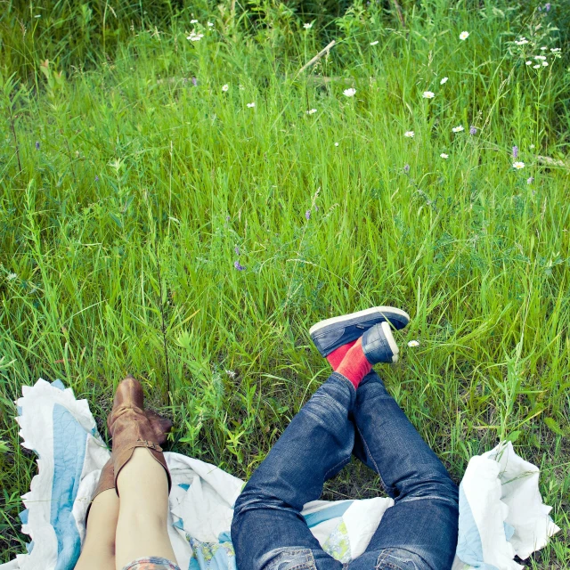 a couple relaxing on a blanket on the grass