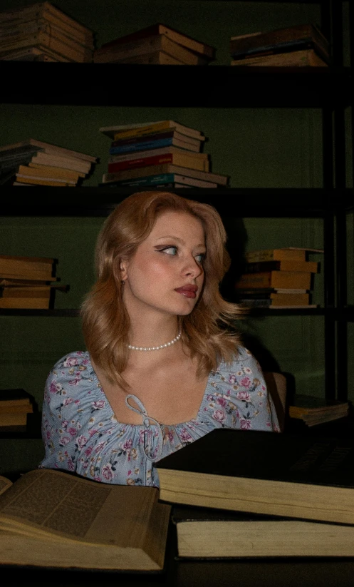 a young lady sitting at a table with books