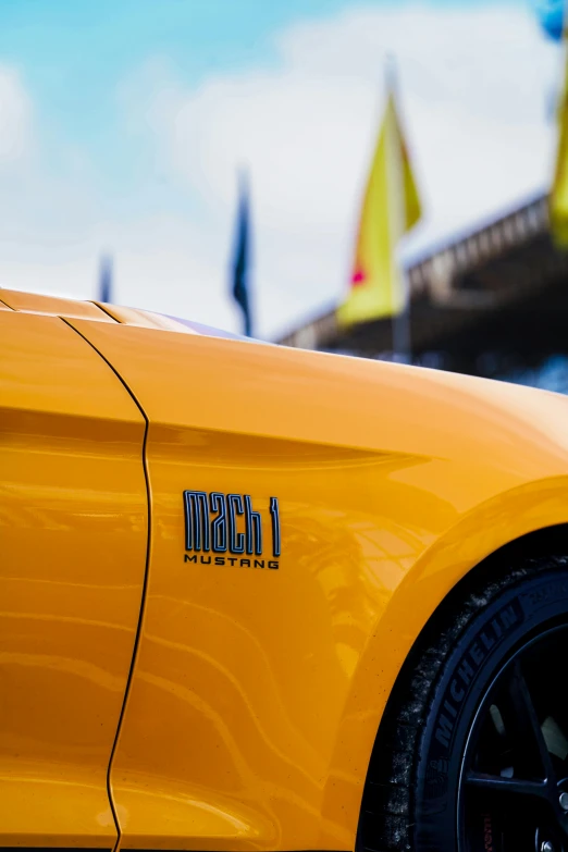 a close up of a yellow car with it's hood emblem