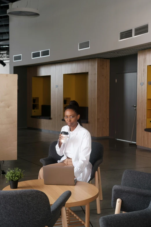 a woman holding up a laptop on the floor