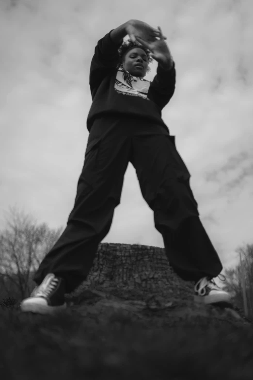 a man holding a phone in one hand and standing on top of a rock