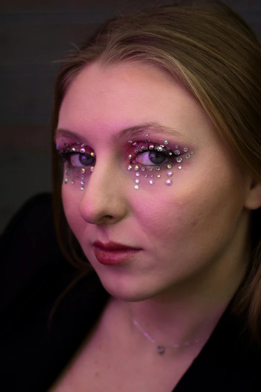 a woman with purple eyes and glitter on her face