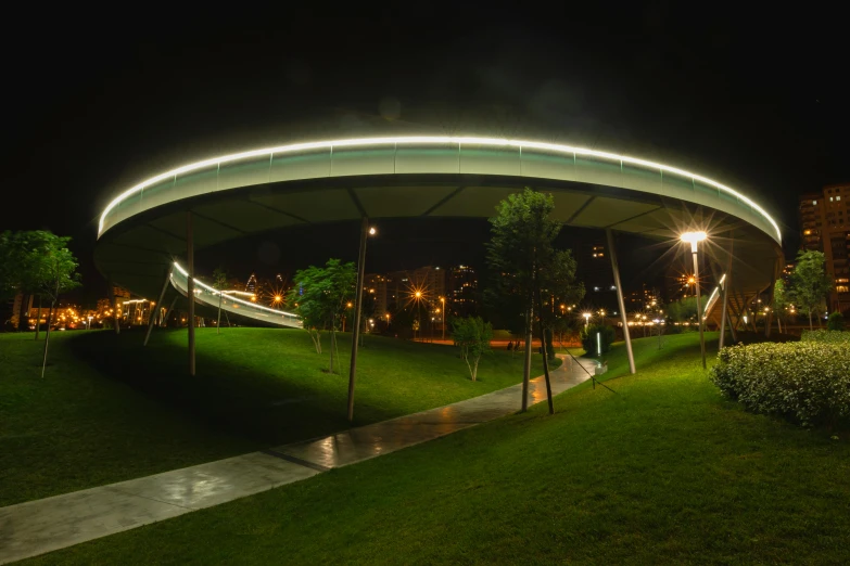 a grassy hill covered in green trees next to a playground