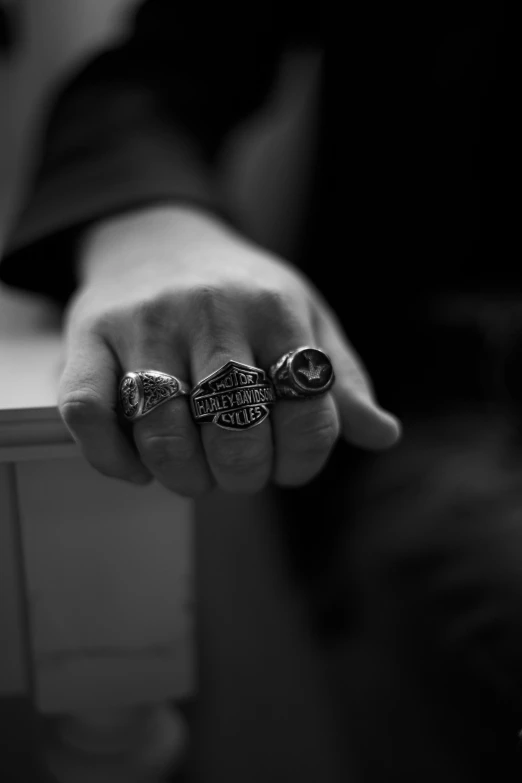 a black and white po of a person holding three rings