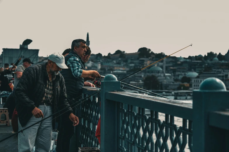 people standing on a bridge with many boats in the water