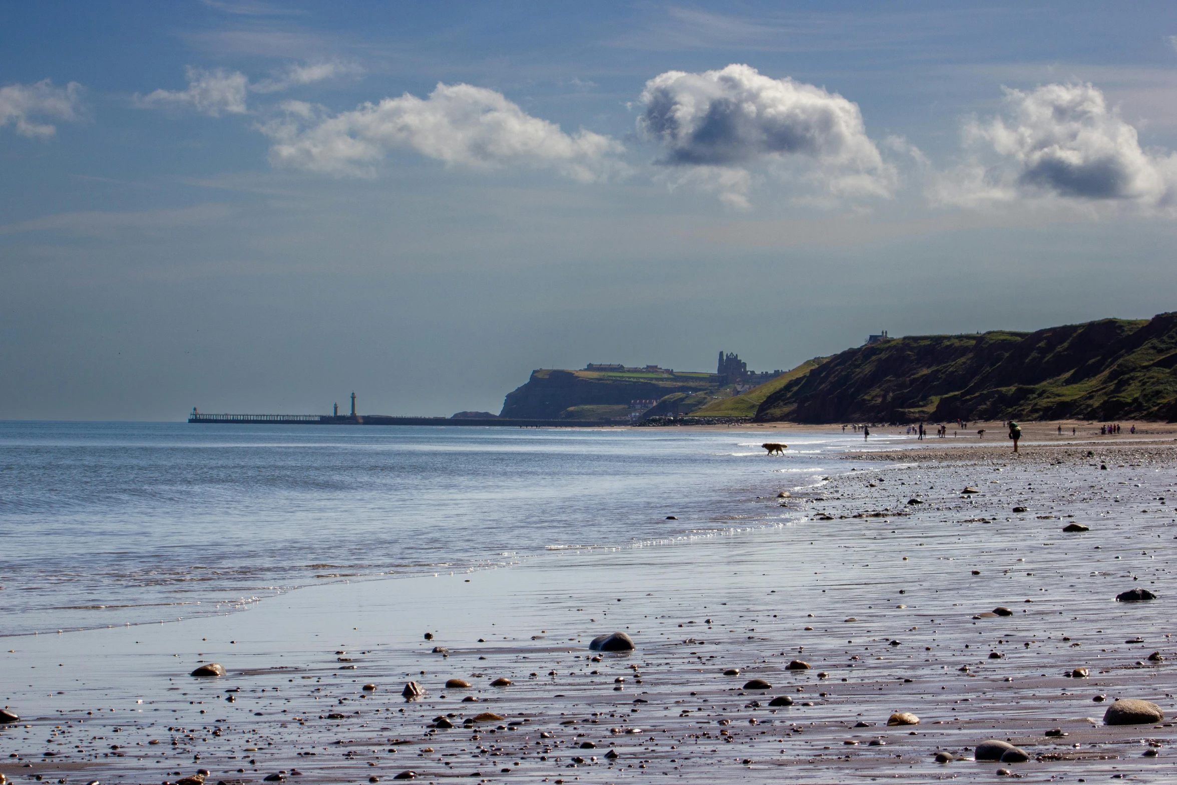 a view from the beach of the ocean near a sand dune