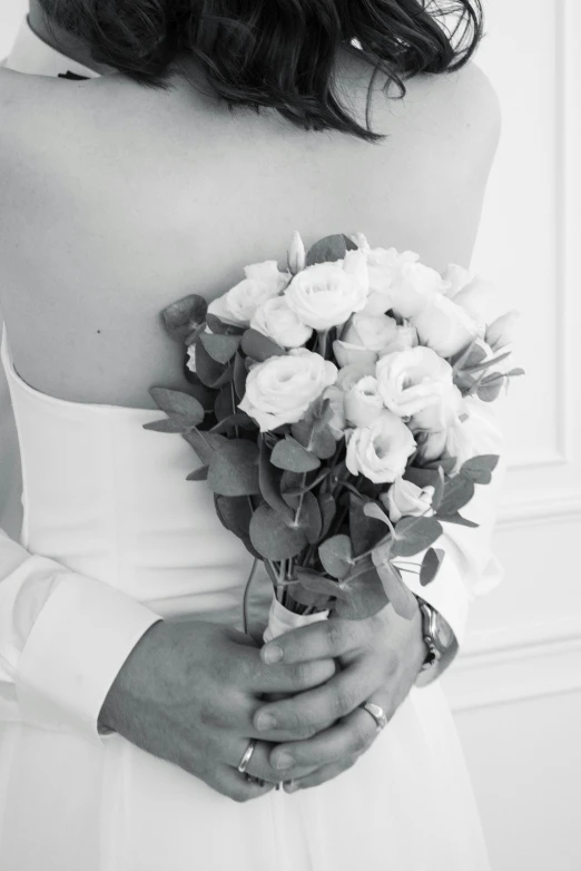 a beautiful young woman in a dress holding a bouquet of flowers