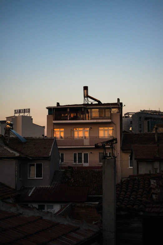 rooftops in a city are seen at night with windows lit up