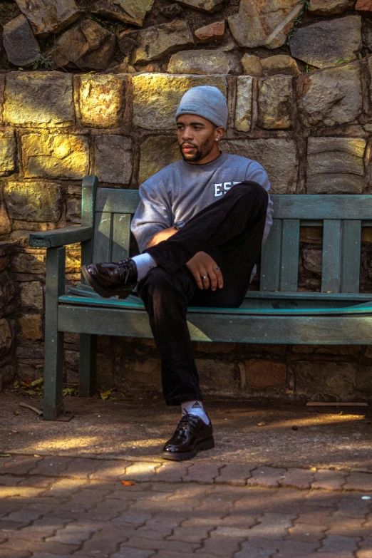 a man with a hat and pants sitting on a bench