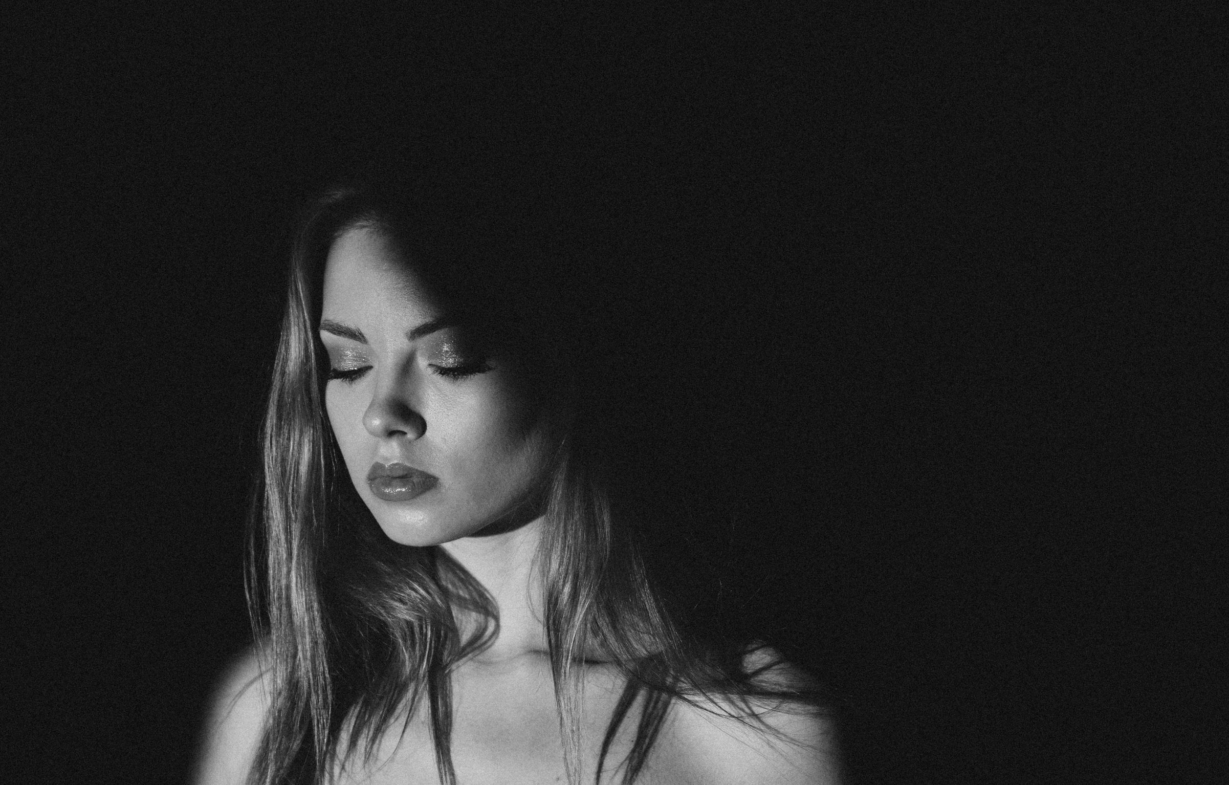 woman in dark room with one face up to the camera