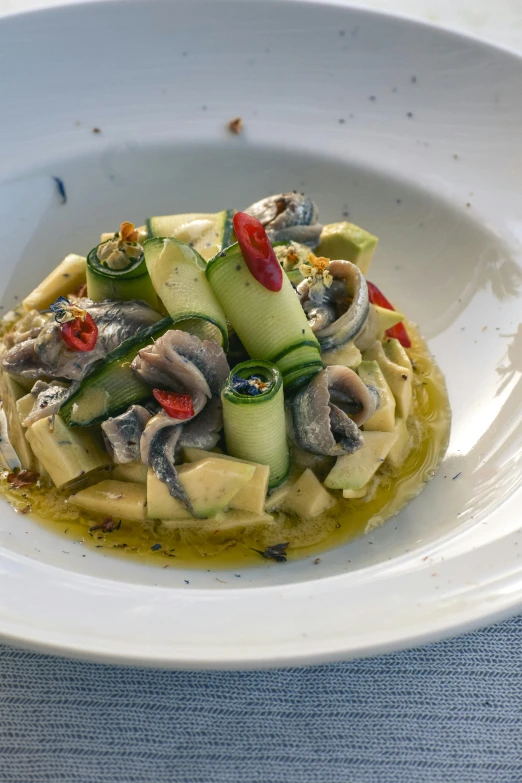 a small white plate with noodles and vegetables