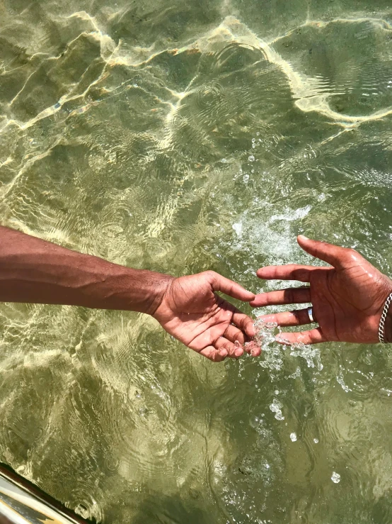 a person holding an open hand over water