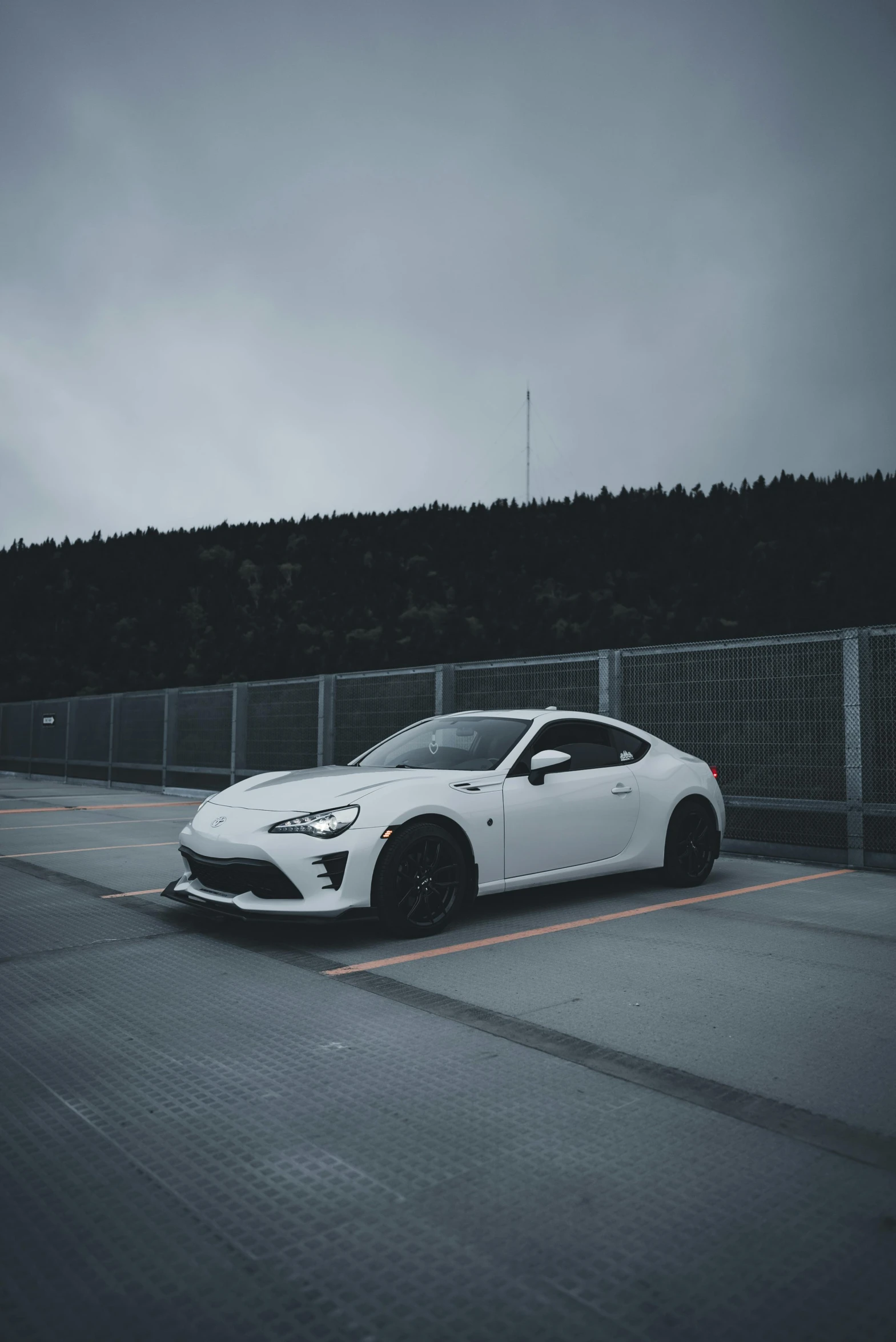 the front of a white sports car parked in a parking lot