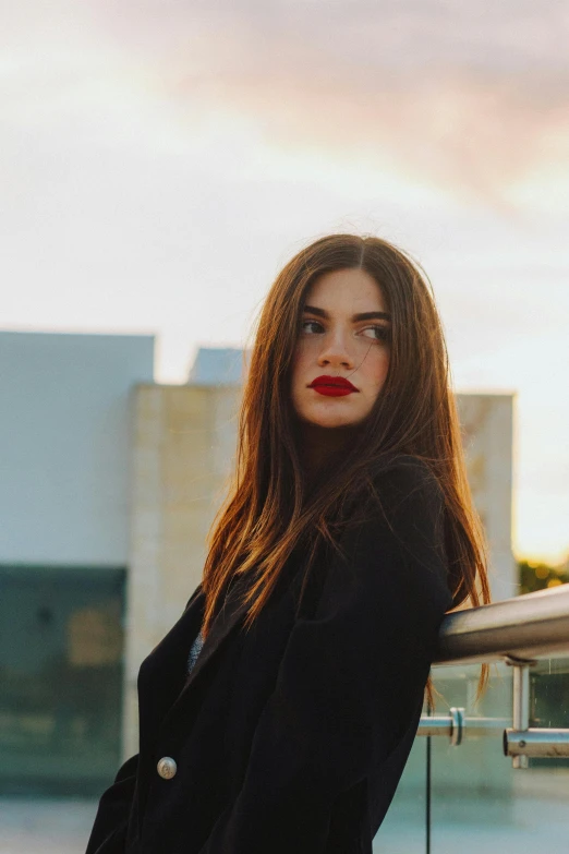 woman in black clothing leaning on railing