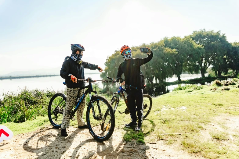 two men with bicycle helmets, standing next to each other