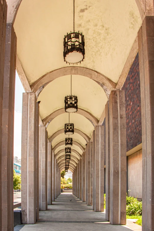 a walkway lined with rows and lamps over top