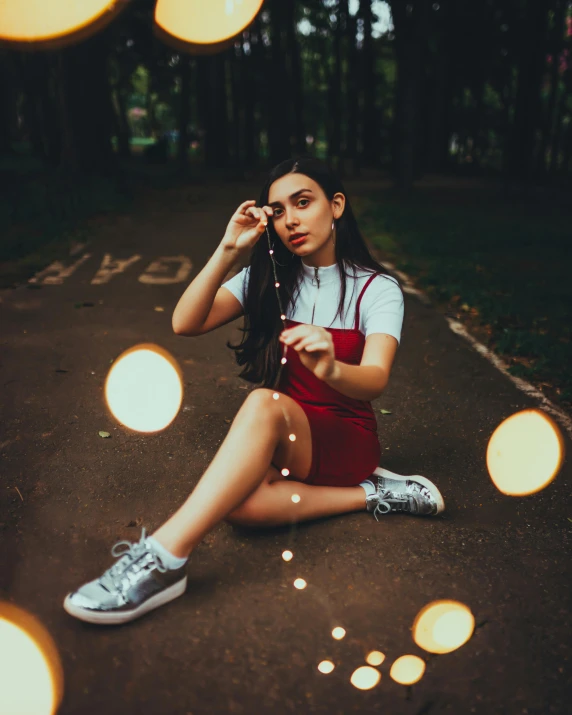 a woman sitting down with many lights behind her