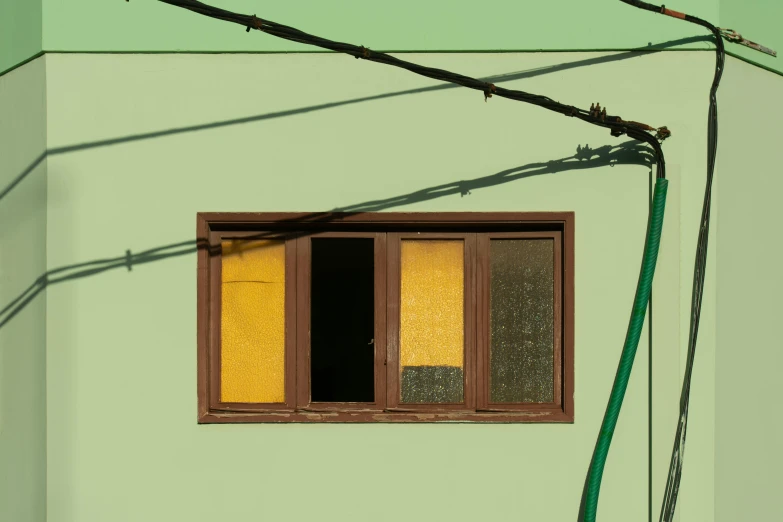 a green building with a yellow window is shown