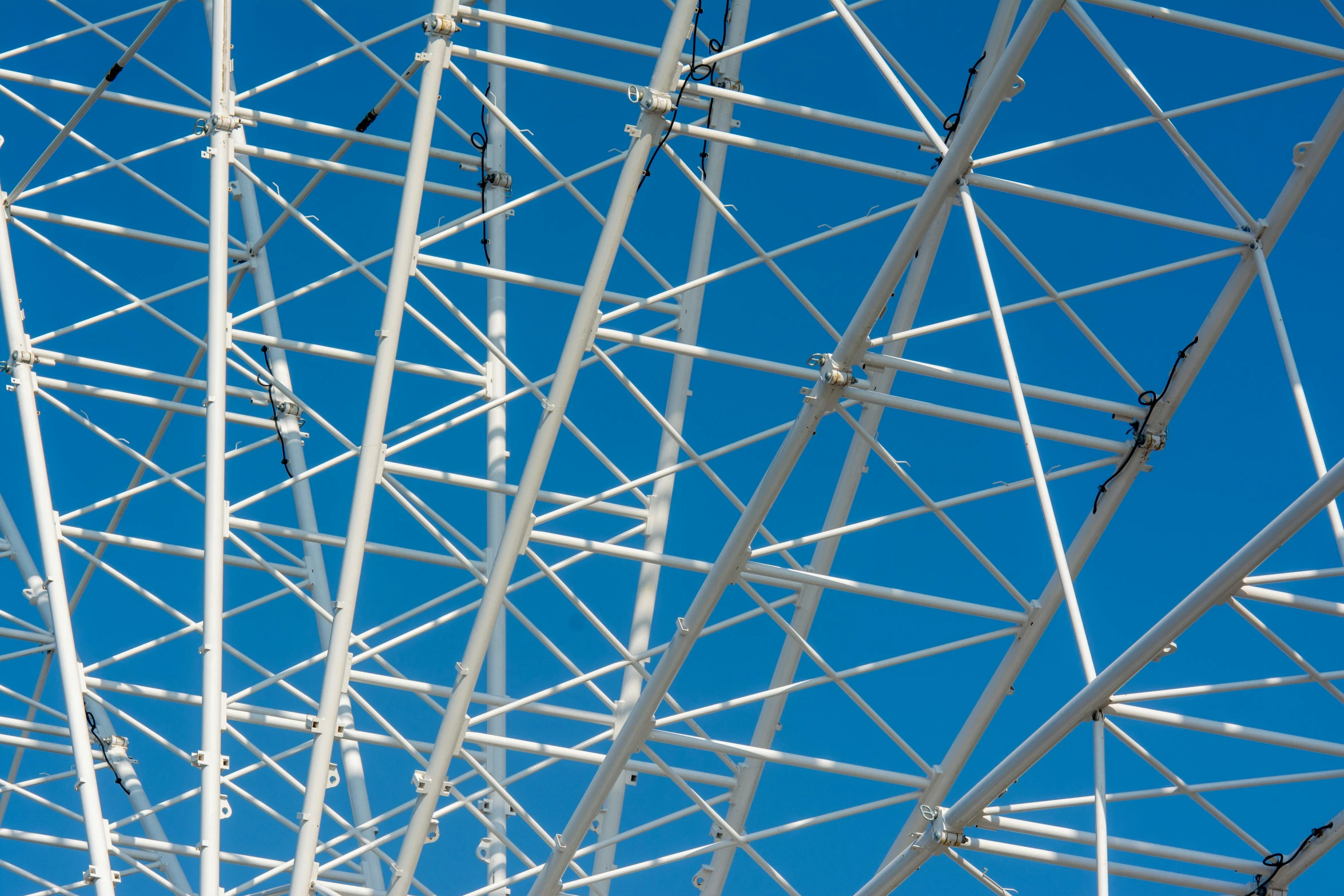 the top of an abandoned ferris wheel against a blue sky