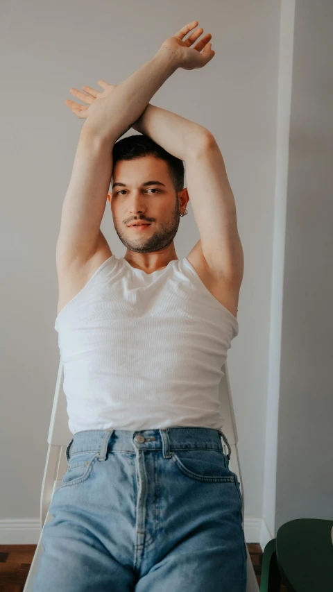 the young man is sitting down with his arm raised above his head