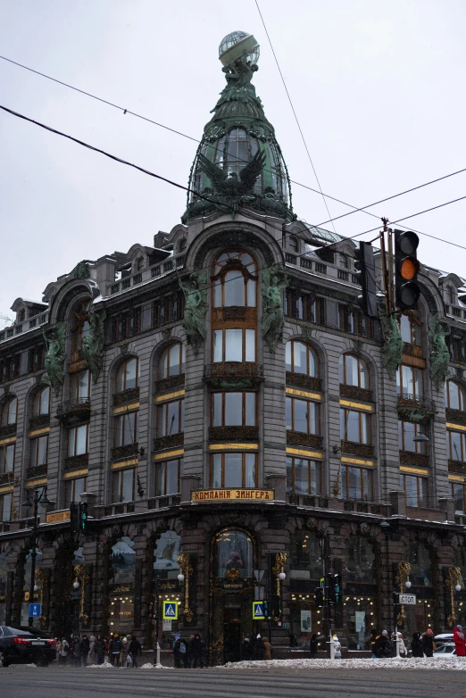 an ornate building on a rainy day with traffic lights and cars