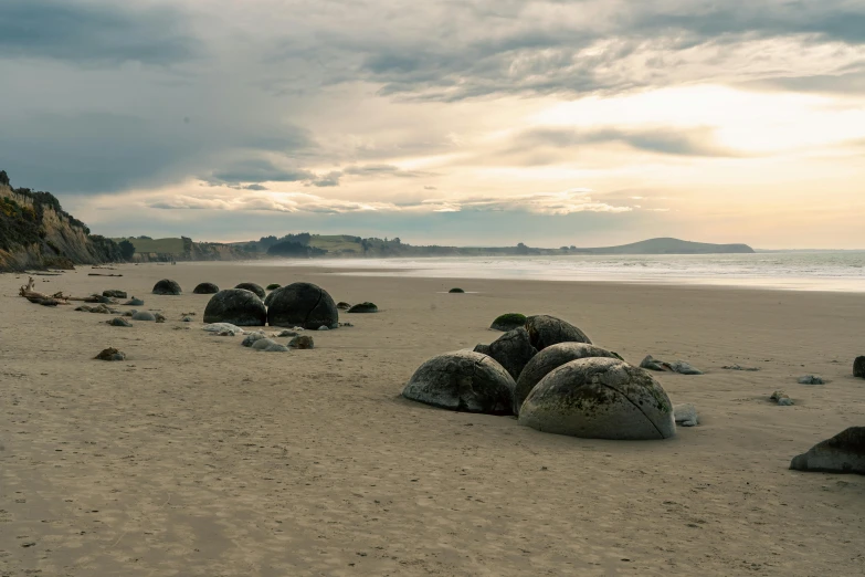 a couple of big rocks in the middle of a sandy beach