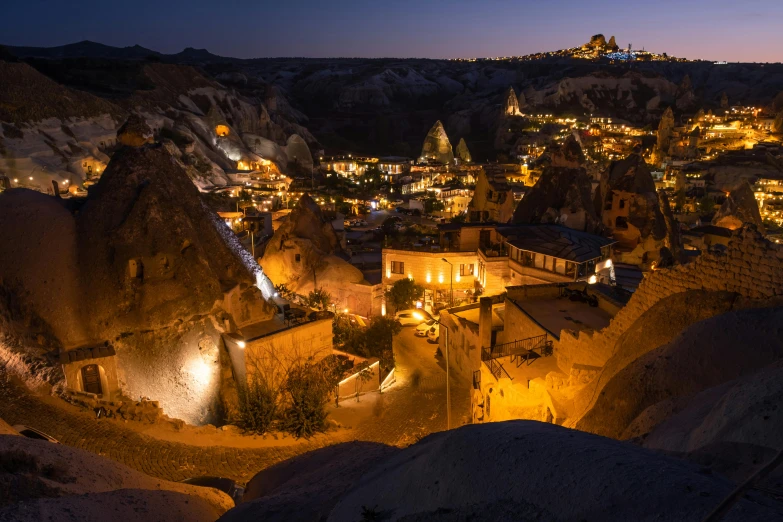 aerial view of a town at night with a town on a hill in the background