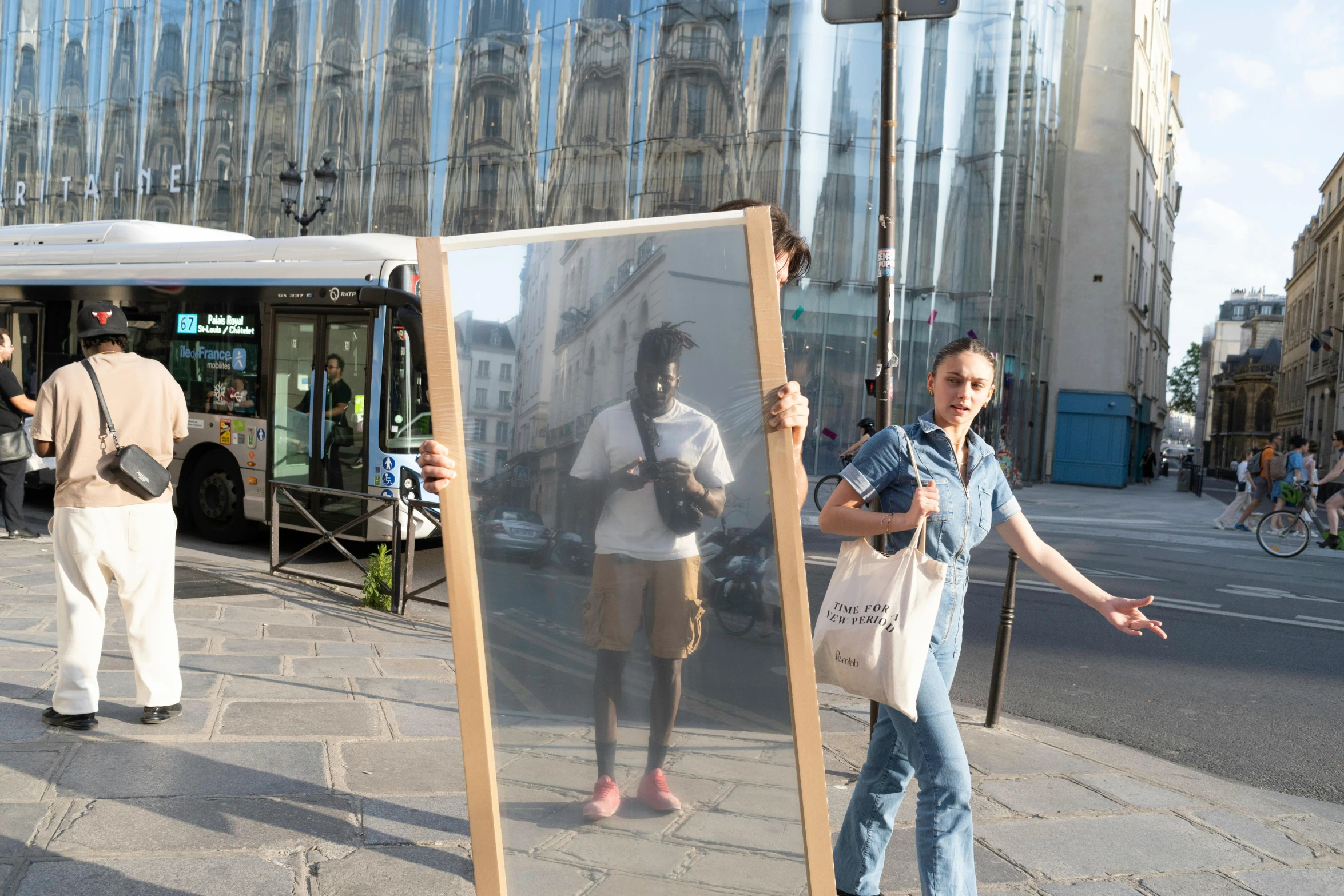 a reflection of a lady and man on the side of the road