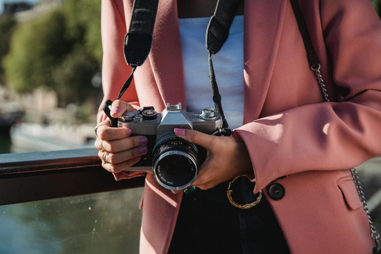 a woman in a pink jacket holding a camera