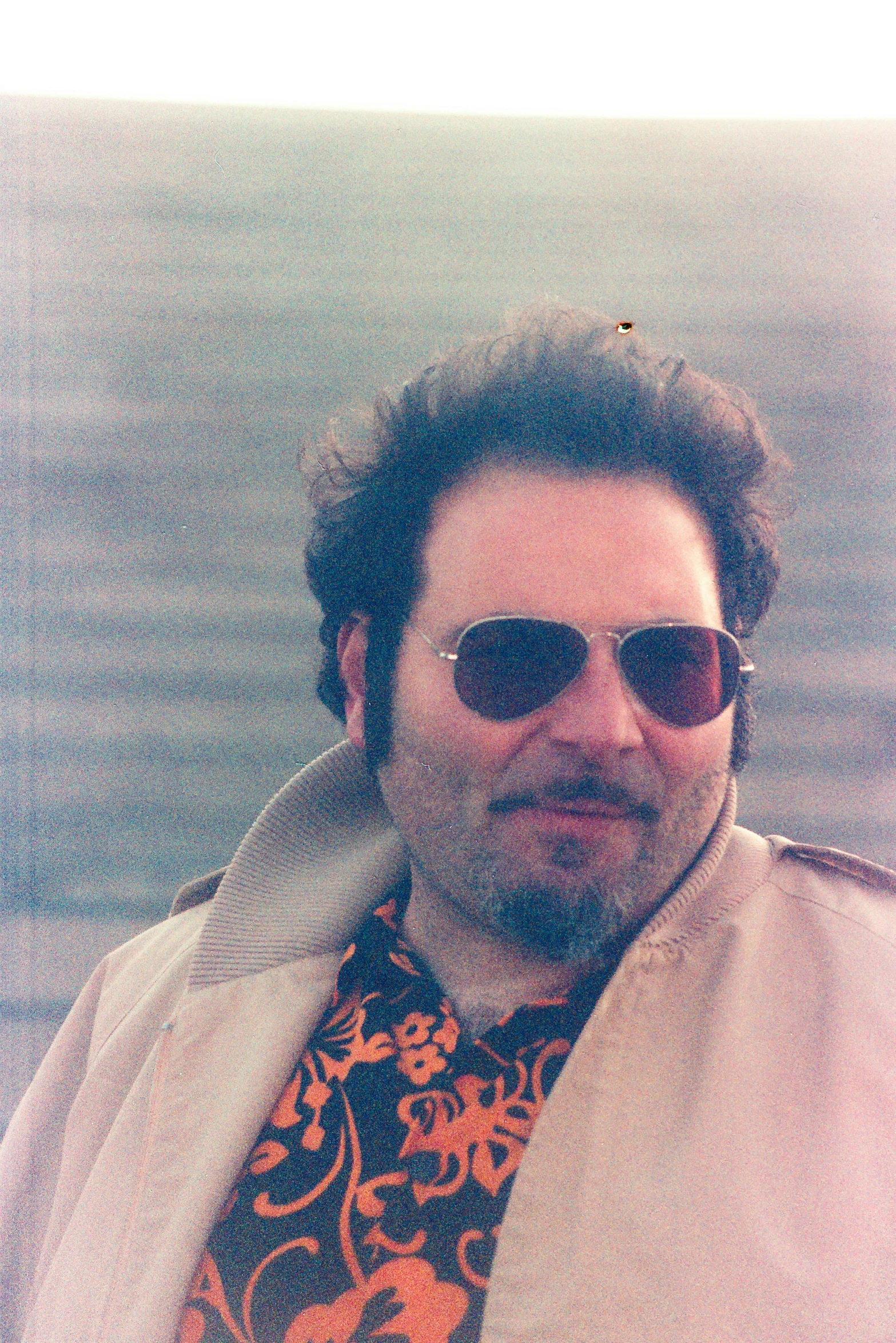 a man wearing a brown scarf and sunglasses with flowers on it