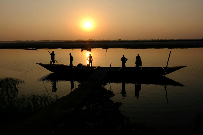 people are standing on the front end of a small boat