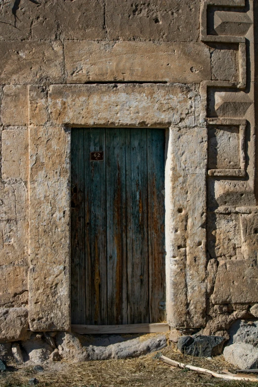 a building has an old door, and two stone pillars