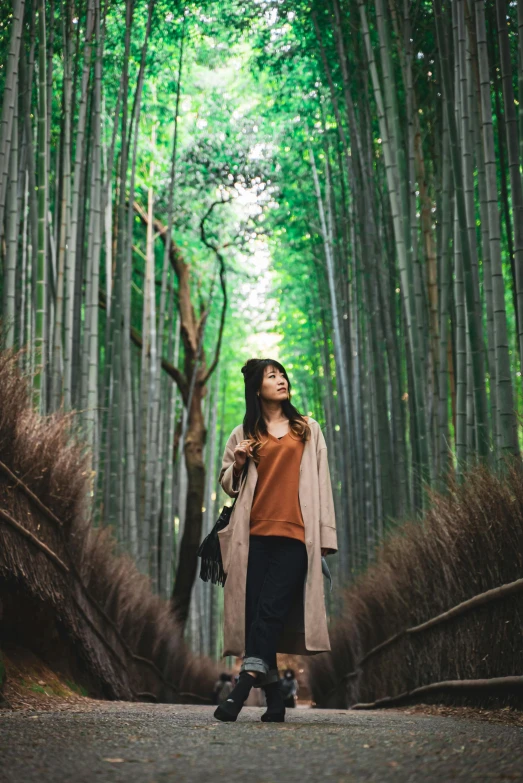 a woman is standing in front of a line of trees