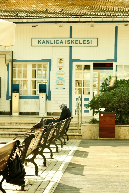 a person is standing on the street next to a bunch of benches