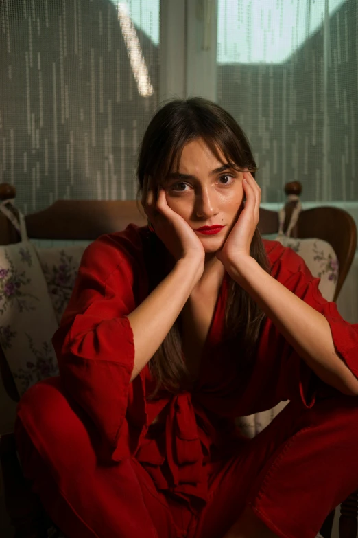 a young woman sitting on a chair looking at the camera