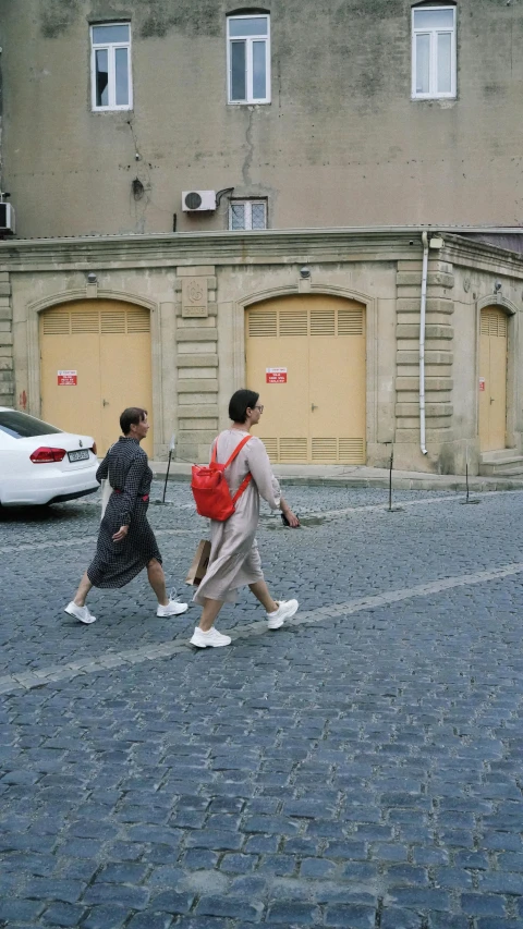 two people are crossing the street as they make their way