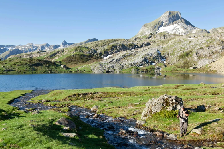 a small mountain lake that is in the grass