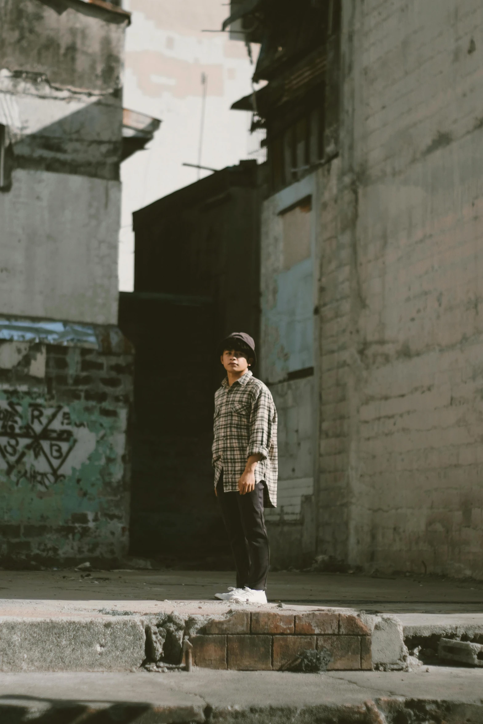 a man standing on top of a brick platform next to an alley way