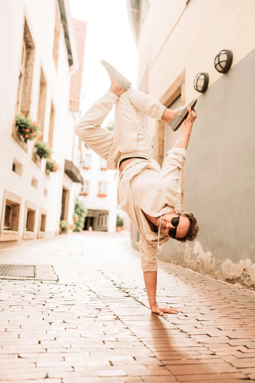 a person in white pants performing an upside down maneuver