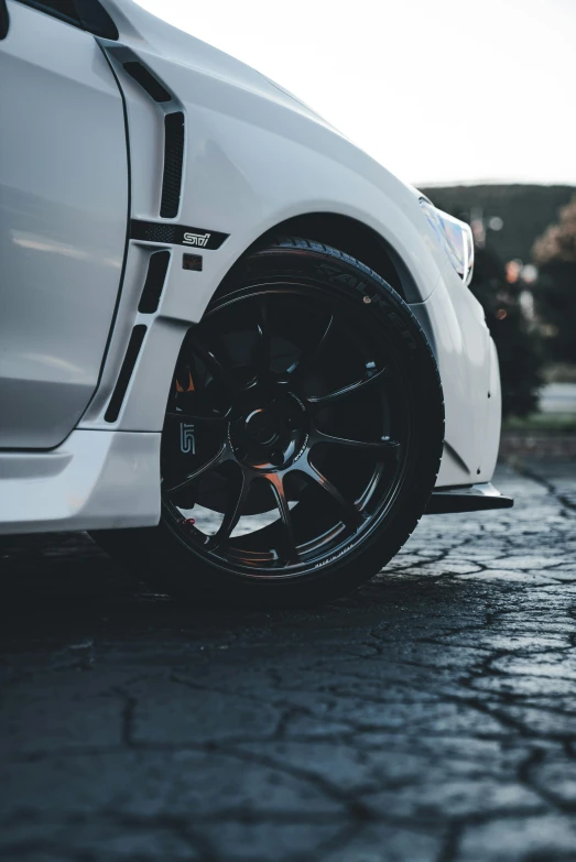 white car parked on street with dark rim